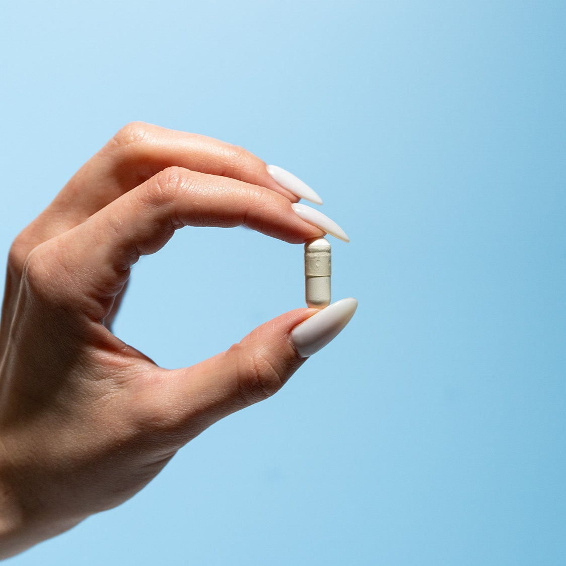 Hand holding magnesium capsule