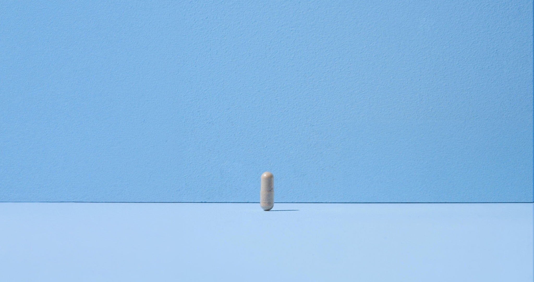 A single centred capsule on the same blue background